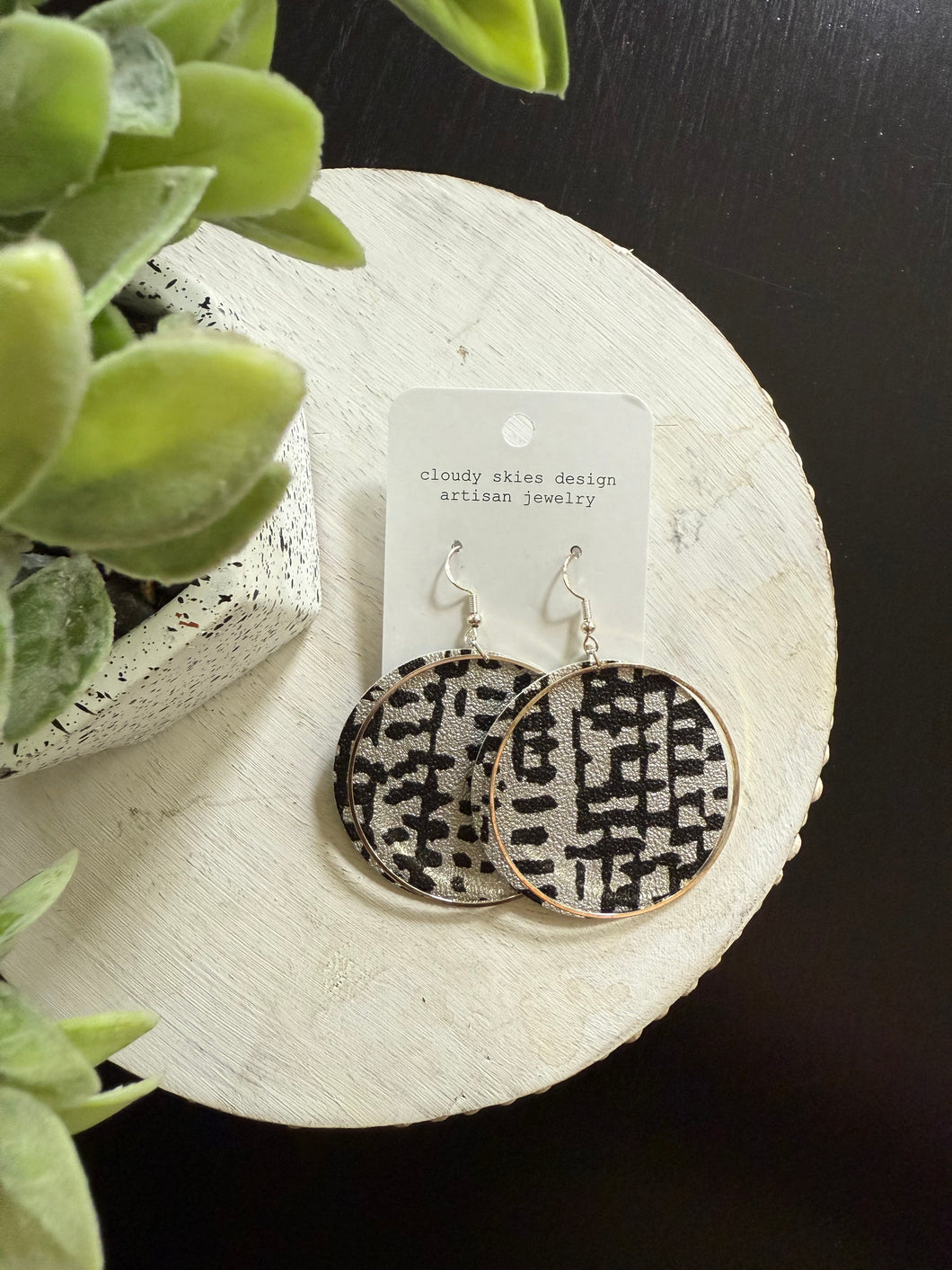 fun wallpaper that is black and silver with silver metal accent earring